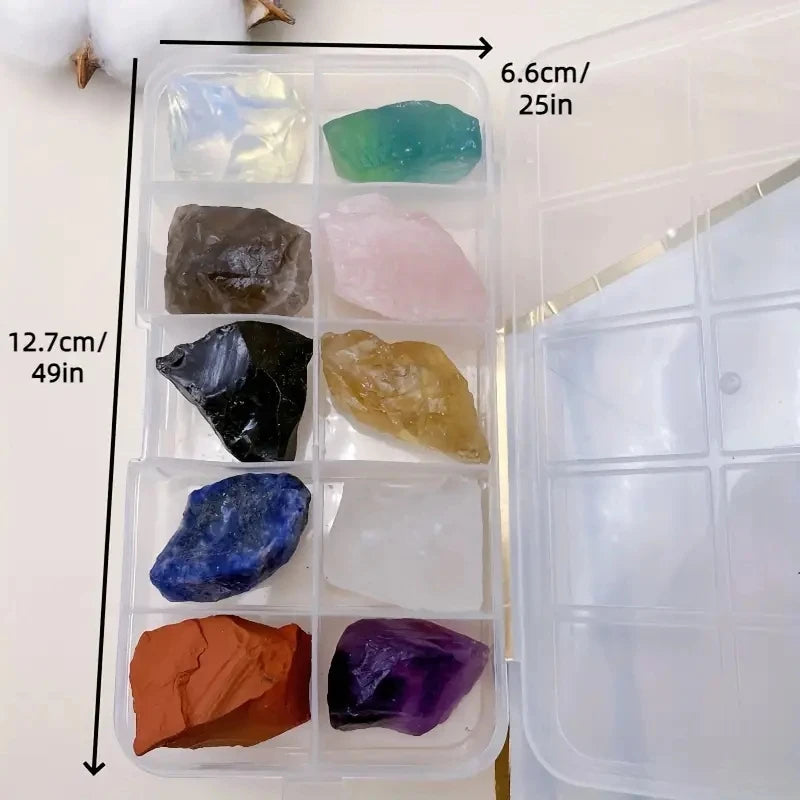 A clear plastic container holds various natural crystal stones including green, pink, black, blue, and purple varieties.