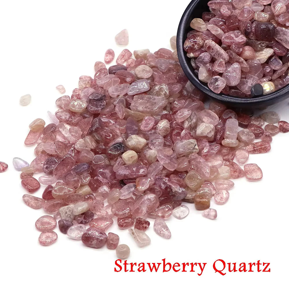 Una pila de cristales de cuarzo de fresa rosados y rojizos junto a un pequeño cuenco negro.