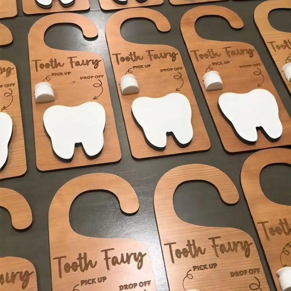 A collection of wooden tooth fairy door hangers for kids, featuring various tooth shapes and names.