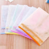 Une pile de tampons de protection anti-chaleur pour le fer à repasser dans diverses couleurs pastel, y compris rose et orange