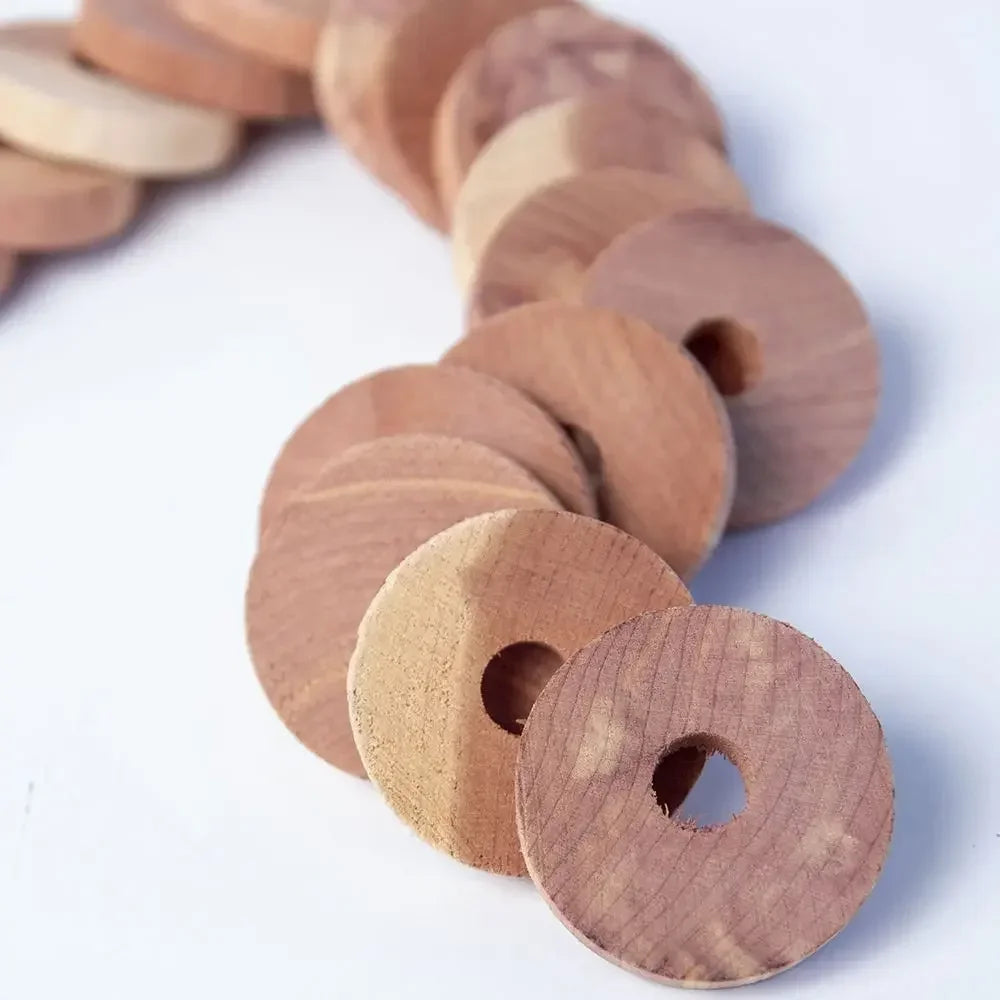 A row of natural cedar wood blocks with circular holes, used as pest deterrents.