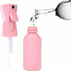 A pink refillable mist spray bottle is shown being filled with water from a glass.