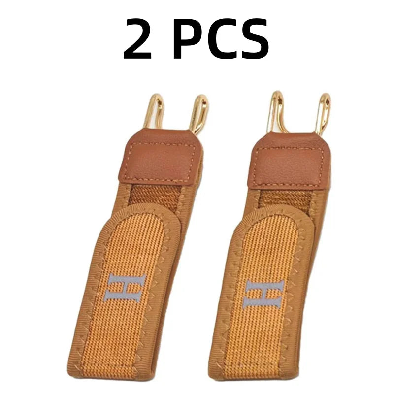 Two tan leather adjustable buckleless belts with silver hardware