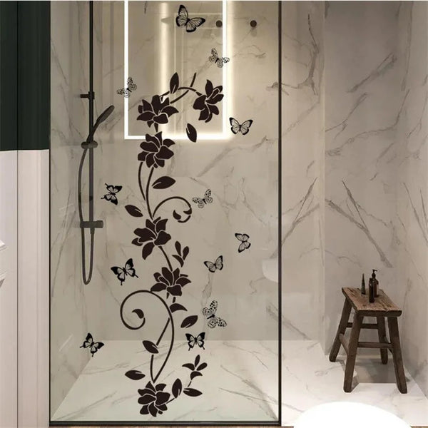 Decorative flower butterfly wall stickers on a clear glass panel in a bathroom or bedroom setting.
