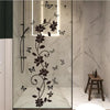 Decorative flower butterfly wall stickers on a clear glass panel in a bathroom or bedroom setting.