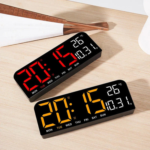 A black digital wall clock displaying the time 20:15, date, and temperature 26°C on a wooden surface.