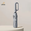 A silver windproof automatic folding umbrella standing upright on a light surface.