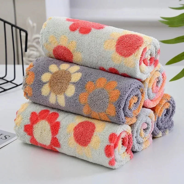 A stack of colorful kitchen cleaning cloths featuring floral patterns in shades of orange, pink, and gray.