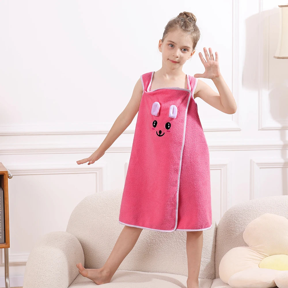 A young girl models a pink microfiber bath towel wrap with bunny ears in a bright room.