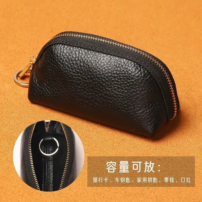Black leather key organizer wallet with a zipper closure shown on an orange background.
