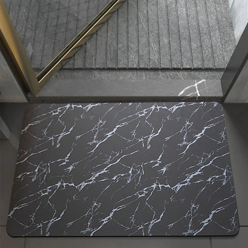 A dark gray marble slab with white veining used as a bath mat.