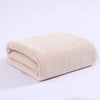 A beige thickened microfiber bath towel folded and displayed on a white background.