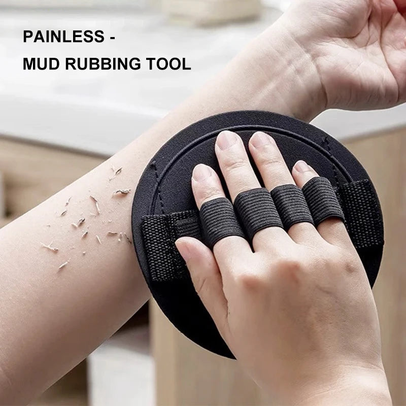 Eine Hand benutzt ein schwarzes Lehmschmirgelwerkzeug am Handgelenk zur Hautpeeling.
