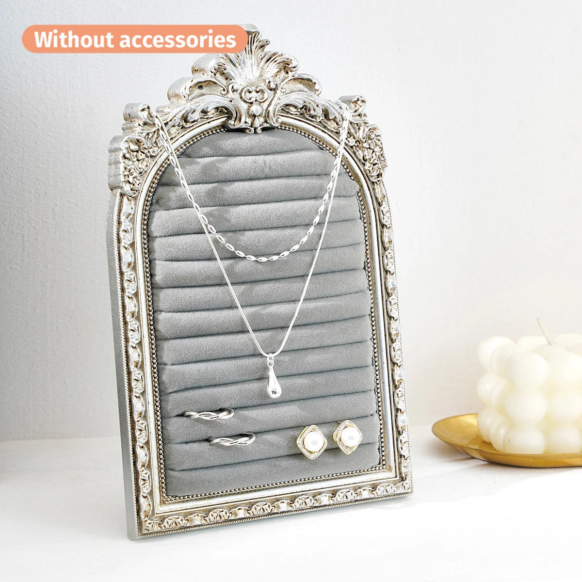 Support orné en argent pour colliers et boucles d'oreilles sur fond de velours gris