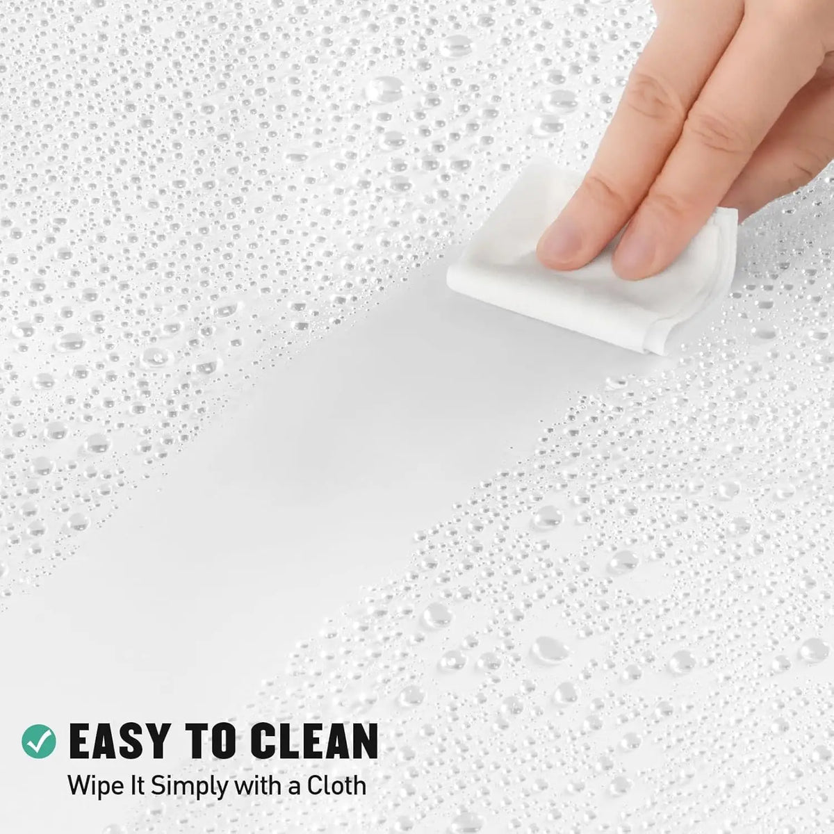 A hand wipes a white shower curtain liner on a wet surface with a white cloth, demonstrating easy cleaning.
