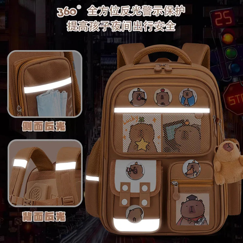A tan backpack with 360-degree light protection features various capybara and animal designs on the front and back.