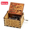 An antique wooden hand crank music box with an engraved lid featuring a romantic message.