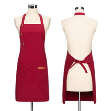 A deep red canvas apron with adjustable straps displayed on a mannequin.