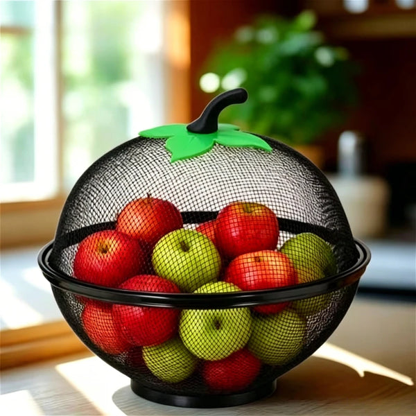 Black metal fruit basket with a green mesh cover filled with fresh red and green apples.
