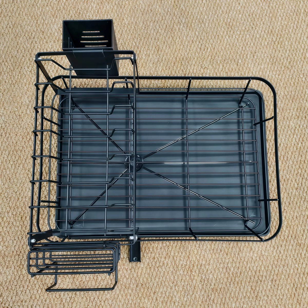 Égouttoir métallique noir à deux niveaux extensible avec plateau rectangulaire et panier de drainage séparé.