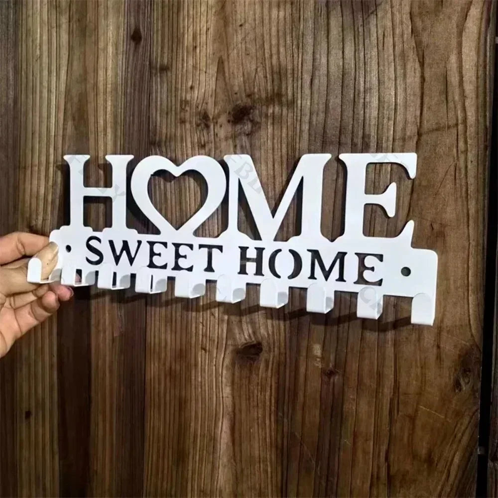 White wooden wall art featuring the words HOME and SWEET HOME cut out in a rustic iron key holder style