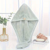A light mint green microfiber hair drying wrap towel with a small bear charm displayed on a white surface.