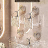 A hanging glass basket storage rack with suction cups mounted on a bathroom wall.