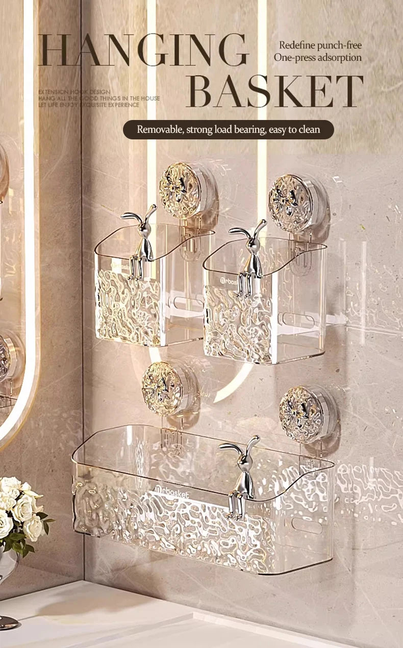 A hanging glass basket storage rack with suction cups mounted on a bathroom wall.