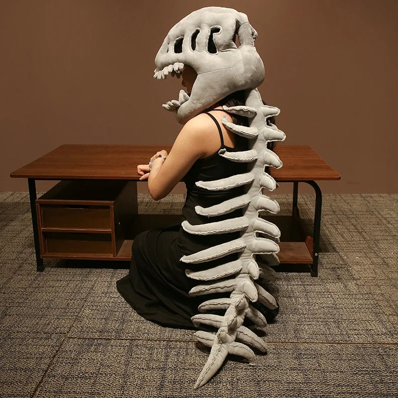 A realistic dinosaur skeleton costume featuring a large skull and vertebral column displayed on a wooden table.