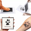 A hand prints a paw on paper, and another shows a black ink pad with a paw print and the name Savannah.