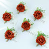 Boutonnière vintage en soie orange avec des fleurs blanches sur une carte.