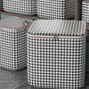 Une pile de sacs de rangement pour vêtements pliables anti-poussière à carreaux noir et blanc sur une étagère.