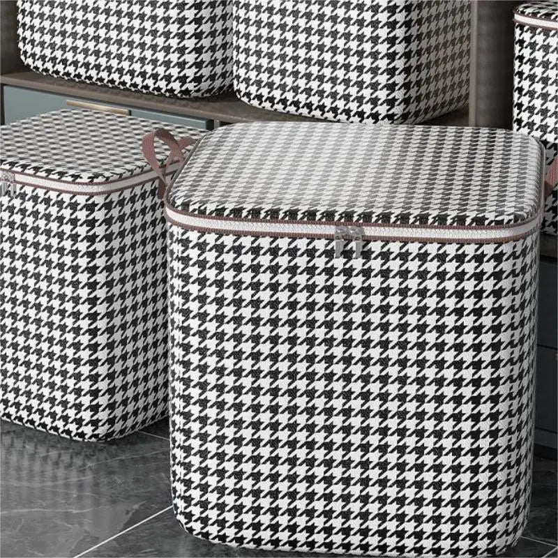 Une pile de sacs de rangement pour vêtements pliables anti-poussière à carreaux noir et blanc sur une étagère.