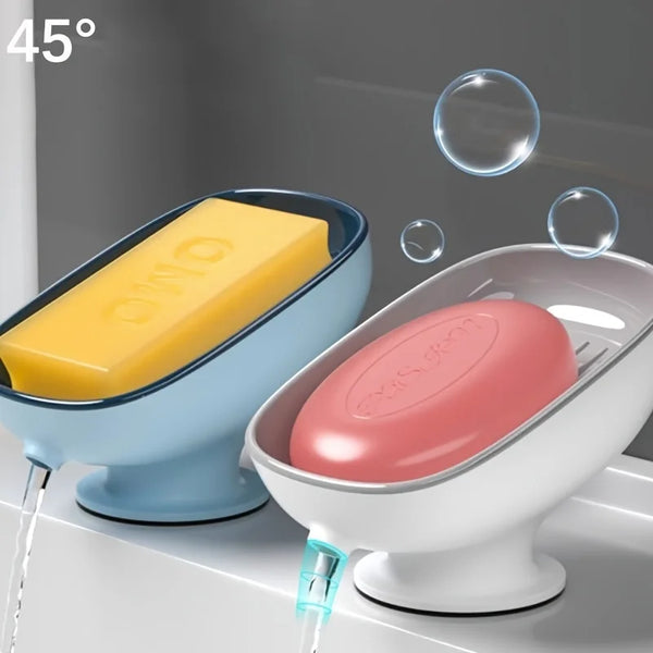 A leaf-shaped bathroom soap dish drainer with a yellow bar of soap is shown draining water.