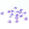 A collection of crushed purple crystal ice stones scattered on a white background.