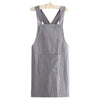 A gray cotton kitchen apron hanging on a wooden hanger.