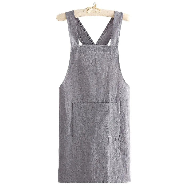 A gray cotton kitchen apron hanging on a wooden hanger.