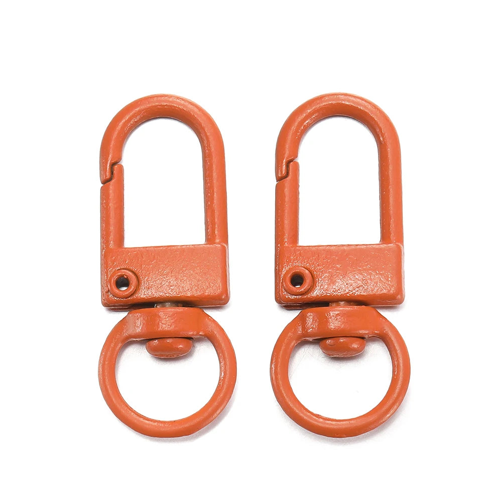 A pair of orange alloy snap lobster clasp hooks for jewelry making