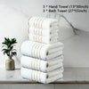 A stack of three white hand towels and three bath towels are displayed on a marble surface.