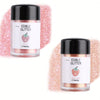 Two glass jars of edible glitter powder, one pink and one rose gold, displayed against a pink glitter background.