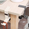 A close-up of an adjustable desk hook bag hanger attached to a light wood desk surface.