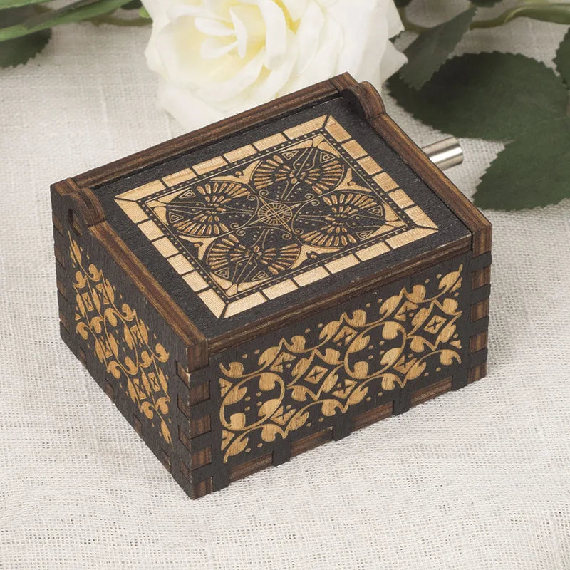 Caja de música de madera tallada a mano con intrincados patrones geométricos y florales sobre un fondo de tela clara.