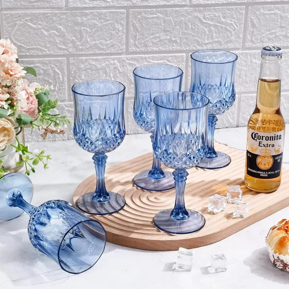 A collection of blue glass champagne flutes and a bottle of Coronita Extra on a wooden board.