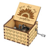 A small wooden music box with a lid featuring a sunflower design and a decorative patterned base.