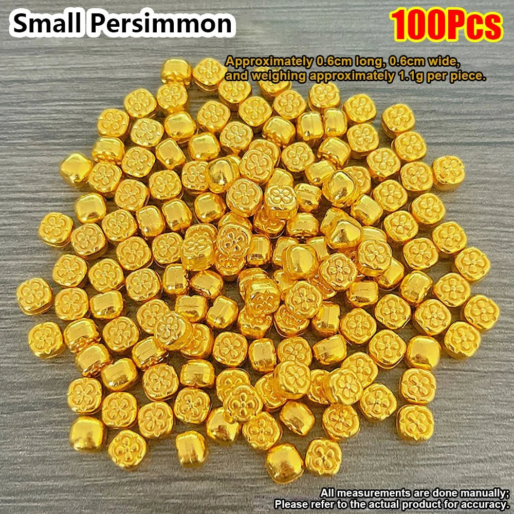 A pile of 100 small gold permimmon decorative ornaments, approximately 0.6cm long and 1.1g each.