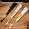 Three wooden folding fans are displayed on a wooden surface, showing black and natural colored lace patterns.