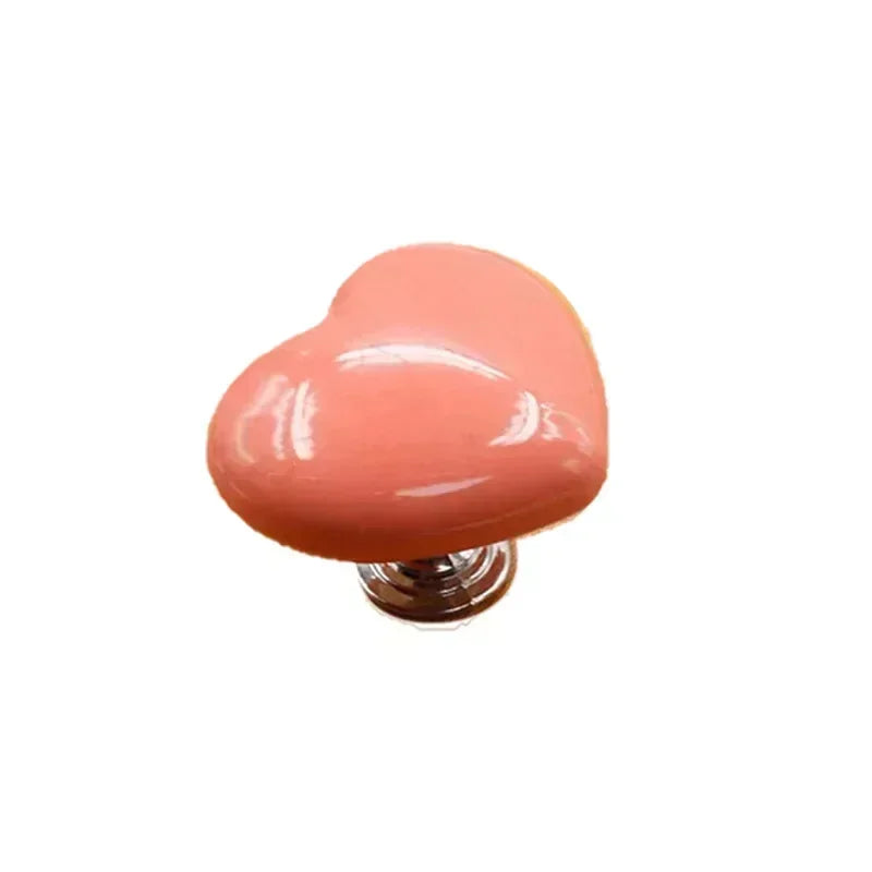 A pink heart-shaped toilet presser button.