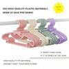 A display of pink, beige, green, and purple plastic clothes hangers for babies and kids.