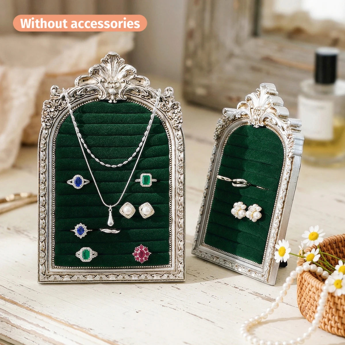 Support de bijoux en argent avec fond velours vert foncé présentant diverses colliers et boucles d'oreilles.