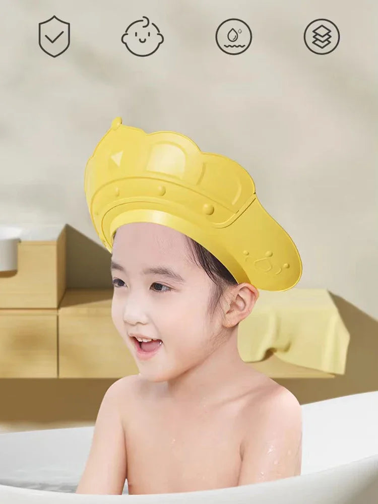 A yellow adjustable baby bath shampoo shield cap is shown on a child, with icons indicating safety and features.